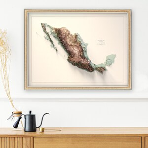 May include: Framed 3D map of Mexico, showcasing the country's topography in shades of brown and green. The map is set against a cream-colored background within a gold-toned frame. The image includes text in the upper right corner.