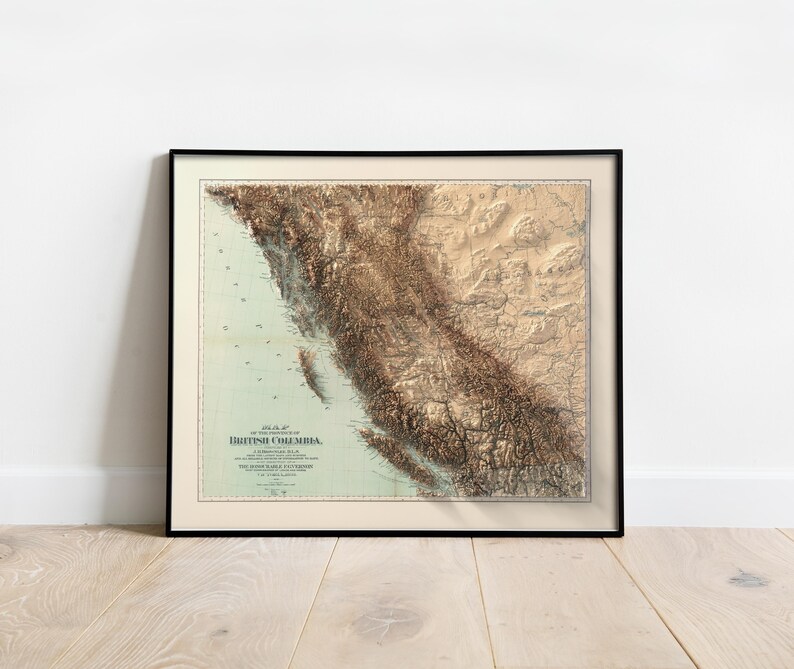 Puede incluir: Un mapa vintage de la Columbia Brit&aacute;nica, Canad&aacute;, con una representaci&oacute;n en relieve del terreno. El mapa est&aacute; enmarcado en negro y tiene un fondo azul claro con l&iacute;neas y marcas marrones y beige.