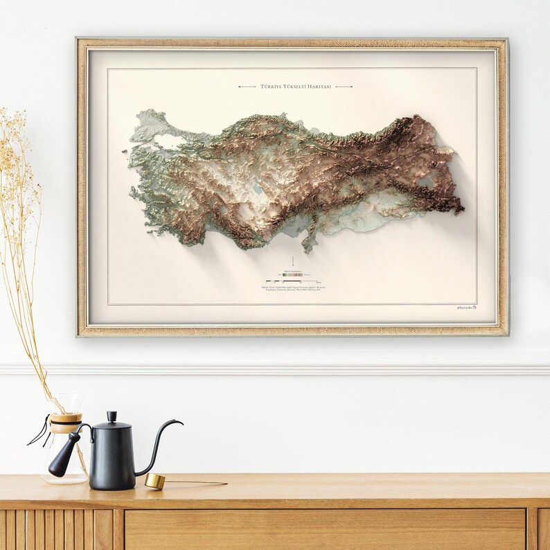 May include: A framed map of Turkey with a 3D relief design. The map is printed on a cream-colored paper with a light brown frame. The title of the map is "T&uuml;rkiye Y&uuml;ksekli Haritası" in Turkish.