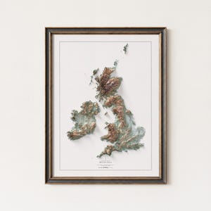 May include: Framed topographic map of the British Isles, featuring detailed relief shading in shades of brown, green, and blue. The map is set against a white background and enclosed in a dark brown frame. The title "British Isles" is visible at the bottom.