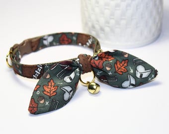May include: A green, brown, and orange cat collar with a bow tie and a bell. The bow tie has a pattern of leaves, acorns, and footballs.