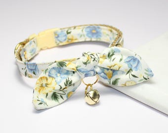 Può includere: Un collare floreale per gatti con fiocco e campanellino dorato. Il collare presenta uno sfondo crema con fiori blu e gialli. Il fiocco è attaccato con un anello dorato. Fibbia in plastica gialla.