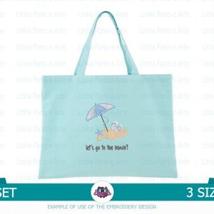 Op de afbeelding: Een lichtblauwe tote bag met een geborduurd ontwerp van een strandparasol, strandstoelen en een emmer en schep. De tekst "Let's go to the beach?" is onder het ontwerp geborduurd.