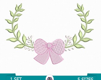 May include: A pink bow with a green leafy wreath on either side. The wreath has small white flowers.