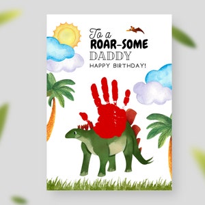 Puede incluir: Una tarjeta de cumplea&ntilde;os con un dinosaurio verde y una huella de mano roja. La tarjeta dice "To a Roar-some Daddy Happy Birthday!"