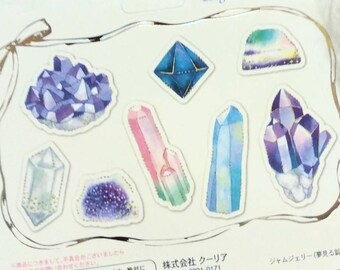 May include: A sticker sheet featuring 8 designs and 48 pieces of various crystal illustrations in shades of purple, blue, and pink. The packaging includes text stating 8 designs 48 pieces, Large size...4 Small size...4, and Japanese text.