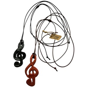 May include: Two treble clef pendants on adjustable cords. One pendant is black, the other is reddish-brown. A small tag with the text "YORK DESIGN" is attached to one of the cords.