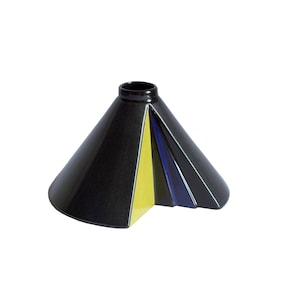 Può includere: Un vaso in ceramica nera con un design geometrico. Il vaso ha un motivo a strisce gialle e blu.