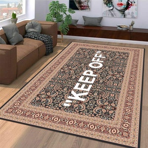 May include: A black and cream patterned rug with a white border and the text "KEEP OFF" in white letters.