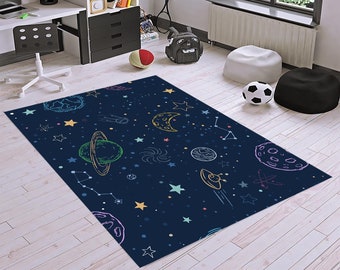May include: A blue rug with a space theme. The rug features planets, stars, and a crescent moon in a colorful, hand-drawn style.