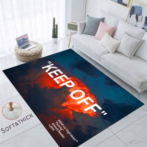 Può includere: Un tappeto morbido e spesso con un design di cielo nuvoloso blu e arancione. Il testo "KEEP OFF" è stampato in bianco sul tappeto. Il testo "IKEA® c/o Virgil Abloh ™™™ "Flooring" Almhult, Svezia c.2019" è stampato in bianco nella parte inferiore del tappeto.