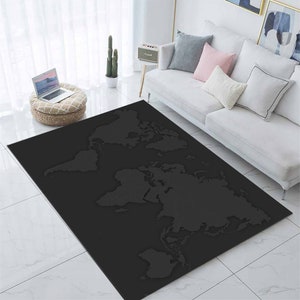 Könnte beinhalten: Ein großer, rechteckiger schwarzer Teppich mit detailliertem Weltkarten-Design. Der Teppich liegt auf einem weißen Fliesenboden in einem Wohnzimmer, mit einem weißen Sofa und dekorativen Kissen im Hintergrund.