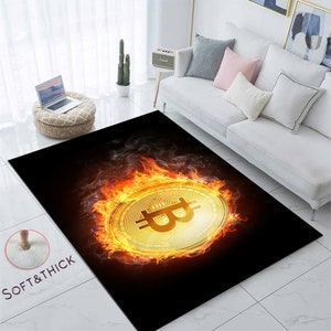 May include: A rectangular black rug featuring a large gold Bitcoin symbol engulfed in flames. The rug has a soft, thick texture, with the words "SOFT&THICK" printed on the lower left corner.