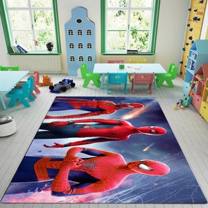 May include: A blue, red, and black area rug with a graphic of three Spider-Man characters. The rug is on a wooden floor in a room with a table and chairs.