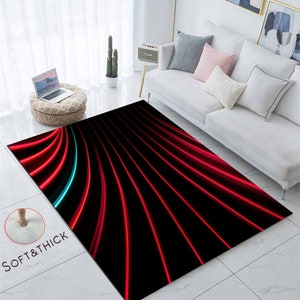 May include: Abstract area rug with a black background and red and blue lines. The rug has a soft and thick texture.