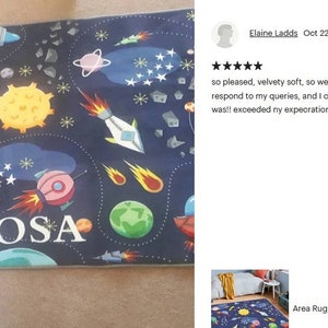 May include: A blue and black space-themed rug with a personalized name "ROSA" in white letters. The rug features rockets, planets, stars, and comets.