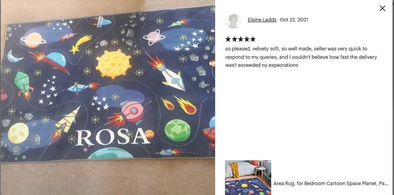 May include: A blue and black space-themed rug with a personalized name "ROSA" in white letters. The rug features rockets, planets, stars, and comets.