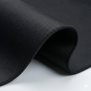 K&ouml;nnte beinhalten: Nahaufnahme eines schwarzen Stoffes mit glatter, gewebter Textur. Der Stoff ist gefaltet und zeigt eine kontrastierende, strukturierte Unterseite und gen&auml;hte Kanten. Das Bild hebt die Tiefe und die Details des Materials hervor.