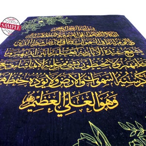 May include: A dark blue fabric with gold Arabic calligraphy. The text reads "ولا يوفر لها في السموات وما في نصرة ما الذي شفع عنده الا بانه يعلم ما بين انديه وما حسية السموات والأرض ولا نورة حفظه وهو العلى العظيم".