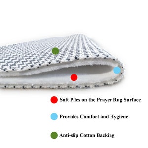 May include: Close-up of a prayer rug with a white and gray geometric pattern. The rug features soft piles, providing comfort and hygiene. It has an anti-slip cotton backing for stability.
