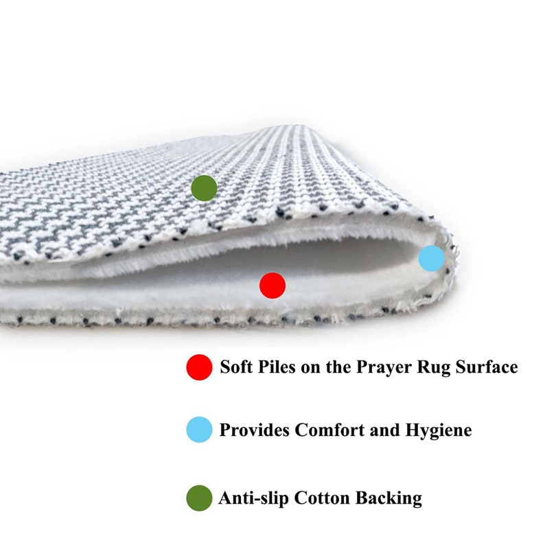 May include: Close-up of a prayer rug with a white and gray geometric pattern. The rug features soft piles, providing comfort and hygiene. It has an anti-slip cotton backing for stability.