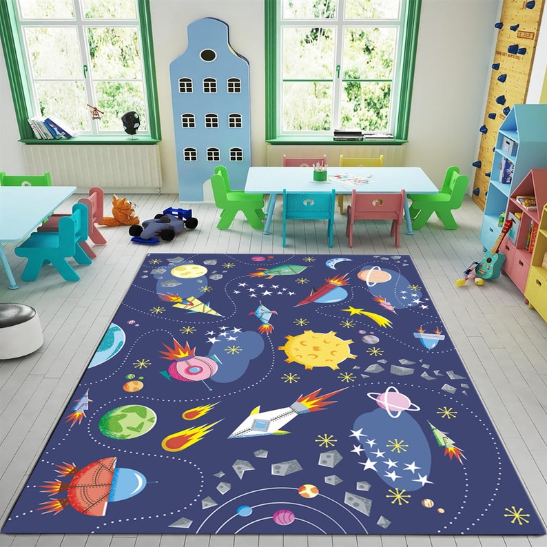 May include: A blue and white space-themed rug with rockets, planets, stars, and comets. The rug is perfect for a child's playroom or bedroom.