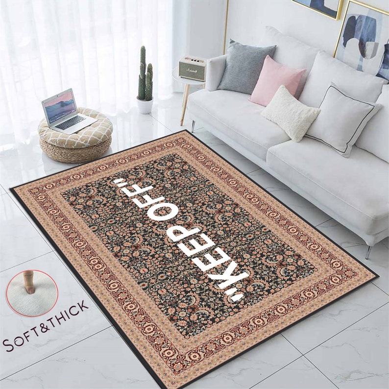May include: A black and beige patterned rug with a white "KEEP OFF" text in the centre. The rug has a soft and thick texture.