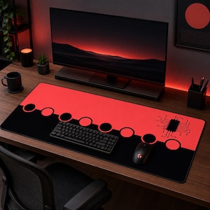 Può includere: Un grande tappetino per mouse rettangolare con una combinazione di colori rosso e nero. La metà superiore è rossa con sei cerchi neri e la metà inferiore è nera con un design a circuito stampato. Una tastiera e un mouse neri sono sopra.