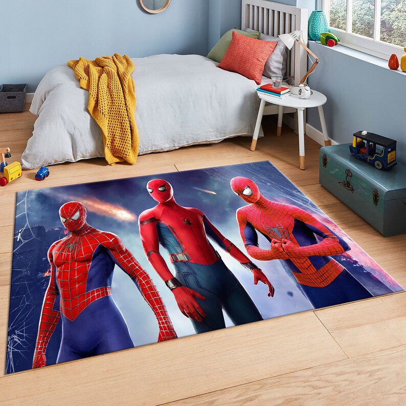 May include: A blue and red area rug with a design of four Spider-Man characters. The rug has a dark blue background with a light blue and white pattern.