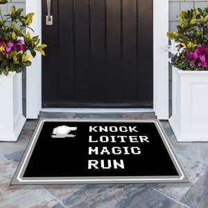 May include: A black and white doormat with a pixelated design. The doormat has the words "Knock, Loiter, Magic, Run" written on it.