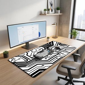 K&ouml;nnte beinhalten: Schwarzes und wei&szlig;es Mauspad mit Leiterplattenmuster. Eine mechanische Tastatur und eine Computermaus befinden sich auf dem Pad. Ein Computermonitor, eine Schreibtischlampe und Topfpflanzen sind ebenfalls zu sehen.