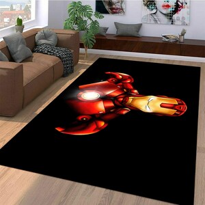 May include: A black area rug with a red and gold Iron Man illustration. The illustration shows Iron Man's face and chest.