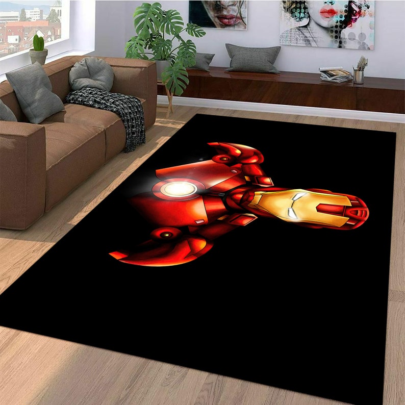 May include: A black area rug with a red and gold Iron Man illustration. The illustration shows Iron Man's face and chest.