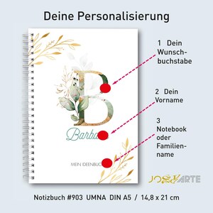 Könnte beinhalten: Ein personalisiertes Notizbuch mit weißem Einband, mit einem großen Buchstaben "B" in Grün und Gold, verziert mit floralen Akzenten. Der Name "Barba" steht darunter. Das Notizbuch ist spiralgebunden und misst 14,8 x 21 cm.
