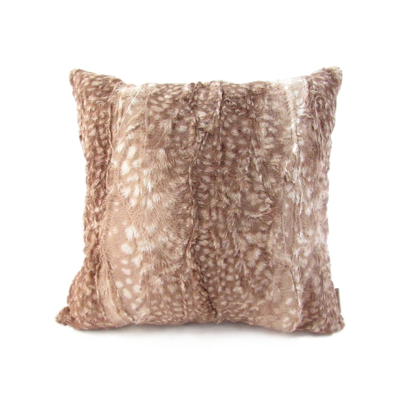 May include: A taupe faux fur throw pillow with a fawn-like pattern. The pillow has a square shape and features vertical stripes of varying shades of taupe and off-white. The texture appears soft and plush, suitable for home decor.