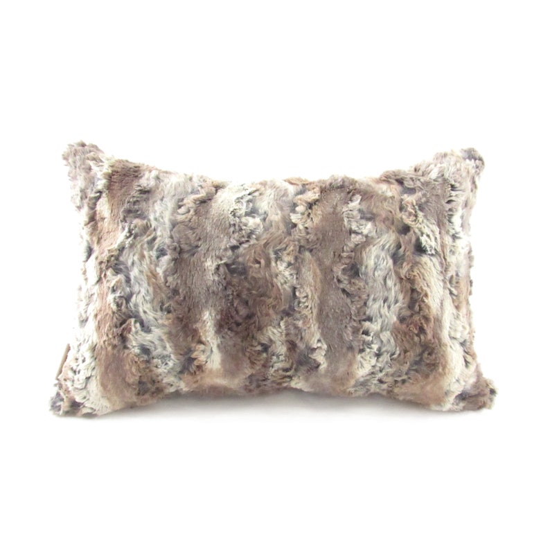 May include: A rectangular brown and gray faux fur throw pillow.