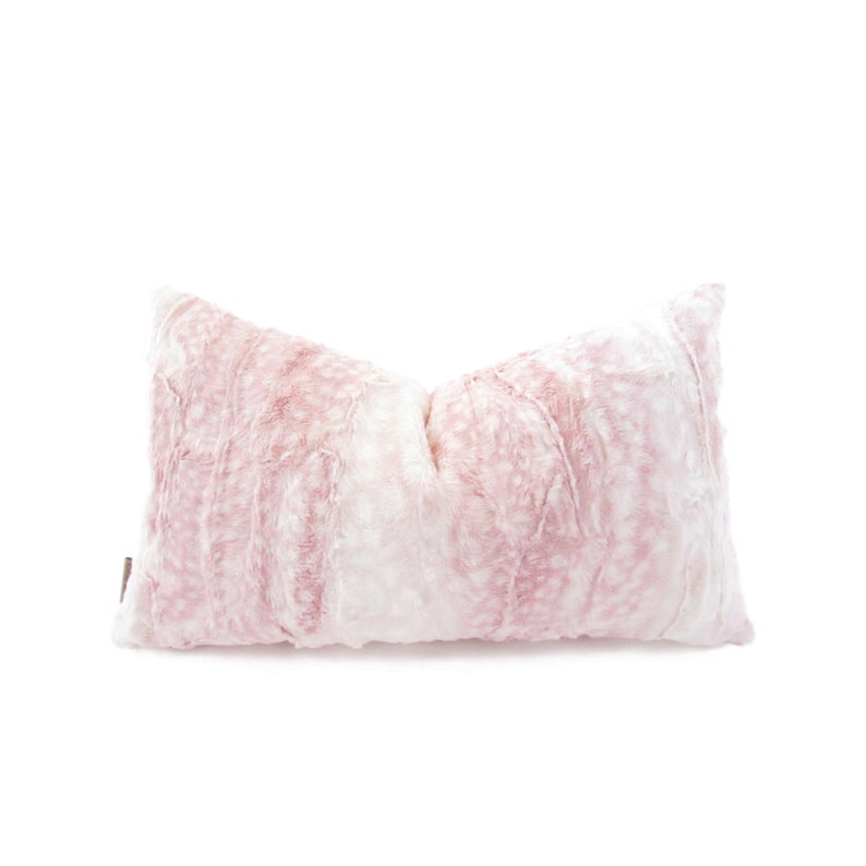 May include: A pink and white faux fur throw pillow with a soft, fluffy texture.