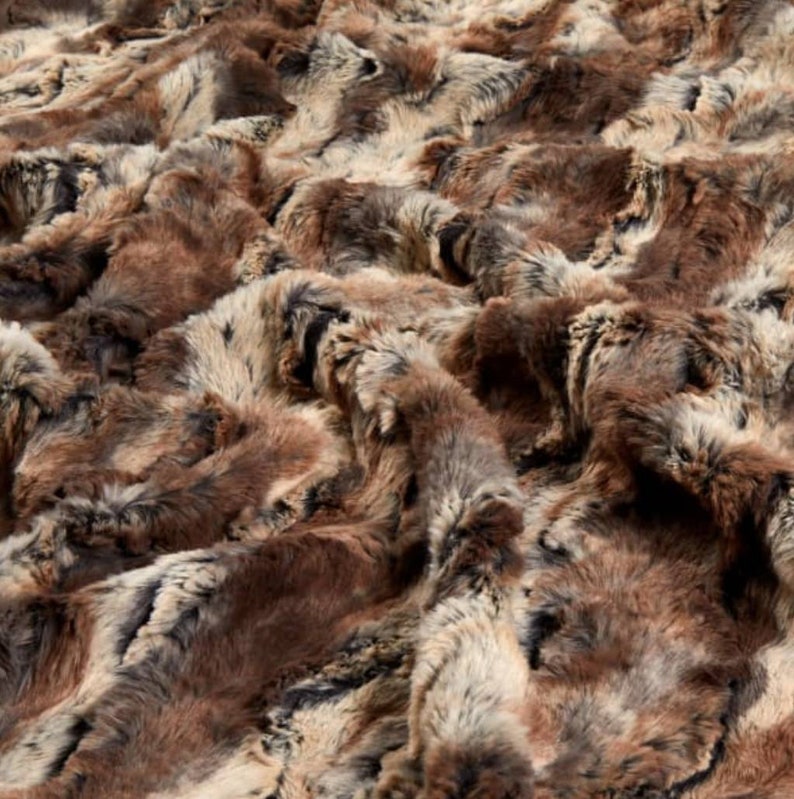 May include: A close-up of a brown and gray faux fur fabric. The fur is soft and fluffy, with a variety of shades of brown and gray.