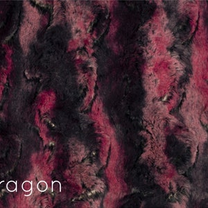 K&ouml;nnte beinhalten: Nahaufnahme eines weichen, pl&uuml;schigen Stoffes mit einem wirbelnden Muster aus Dunkelrot und Schwarz. Der Stoff hat eine flauschige Textur und ein luxuri&ouml;ses Gef&uuml;hl. Der Text "Dragon" ist unten im Bild in Wei&szlig; gedruckt.