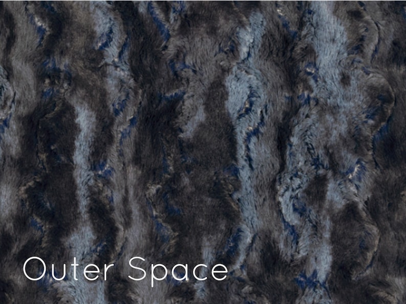 K&ouml;nnte beinhalten: Ein Pl&uuml;schstoff in einem dunkelgrauen und blauen Farbschema. Der Stoff hat eine flauschige Textur und ein wirbelndes Muster. Der Text "Outer Space" ist unten im Bild gedruckt.