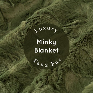May include: Close-up of a soft, plush green minky blanket. The blanket has a luxurious, faux fur texture. The text "Luxury Minky Blanket Faux Fur" is printed on a black circle.