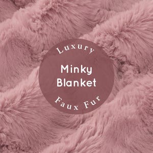 May include: Close-up of a soft, pink, faux fur minky blanket. The blanket has a luxurious feel and is perfect for cuddling up on the couch.