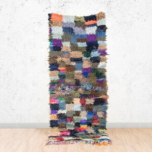 Peut inclure: Un tapis rectangulaire multicolore avec un motif patchwork. Le tapis présente une variété de couleurs, notamment le bleu, le vert, le violet, l'orange et le marron. Le tapis est fait d'un matériau texturé et a une frange le long du bord inférieur. Le tapis mesure environ 152 cm de long.