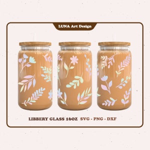 Może przedstawiać: Trzy szklane kubki o pojemności 473 ml z drewnianymi pokrywkami i słomkami. Każdy kubek ma inny układ pastelowych wzorów kwiatowych na brązowym tle. Tekst "LIBBERY GLASS 16OZ SVG - PNG - DXF" znajduje się na dole obrazu.