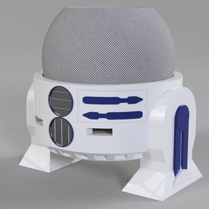 Op de afbeelding: Witte en blauwe R2-D2-thema luidspreker met een ronde, grijze luidsprekerrooster bovenop. De luidspreker heeft twee blauwe rechthoekige details aan de voorkant en twee ronde, zwarte luidsprekerroosters aan de zijkanten.