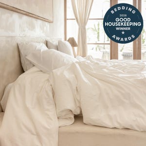 May include: A white bedding set featuring a duvet cover and two pillows on a bed. A circular dark blue badge in the upper right corner displays the text: BEDDING 2026 GOOD HOUSEKEEPING WINNER AWARDS with a star icon in the center of the badge.