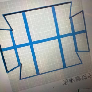 Puede incluir: Un diseño geométrico azul sobre un fondo de cuadrícula. El diseño presenta una serie de rectángulos y líneas conectadas, creando una forma simétrica. La imagen es probablemente un diseño digital o un plano.