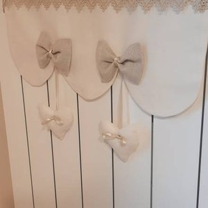 Shabby radiator cover with symmetrical waves with bows and macramé band. Hearts suspended from satin ribbons. Soft colors, mod. "MIREA"