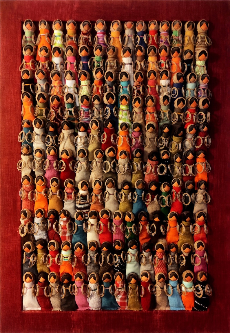 Pu&ograve; includere: Un'opera d'arte incorniciata che presenta una collezione di bambole di stoffa colorate disposte in file. Ogni bambola &egrave; unica, con motivi e colori diversi, creando una mostra vibrante e testurizzata.