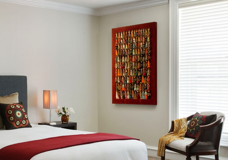 Pu&ograve; includere: Un interno di una camera da letto con un letto, un comodino, una lampada e una sedia. Un grande dipinto astratto con sfondo rosso e figure colorate &egrave; appeso al muro.